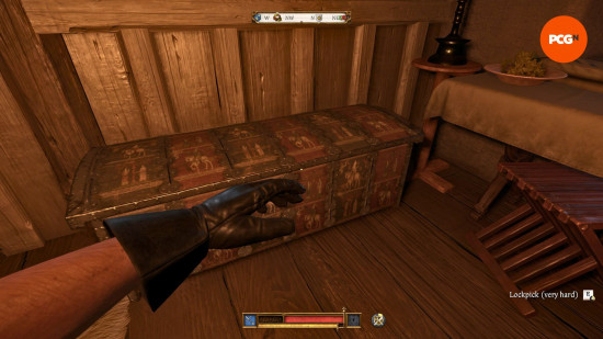 Kingdom Come Deliverance 2 lockpicking: a fire person view of a chest, with the character's left hand in view and they're about to open it.