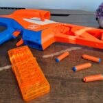 Nerf N-Series Pinpoint and darts on a wooden table, with a pot plant in the background