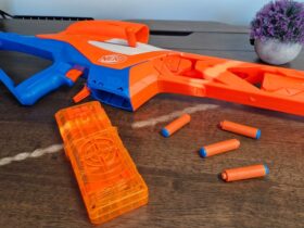 Nerf N-Series Pinpoint and darts on a wooden table, with a pot plant in the background