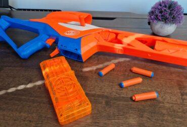 Nerf N-Series Pinpoint and darts on a wooden table, with a pot plant in the background