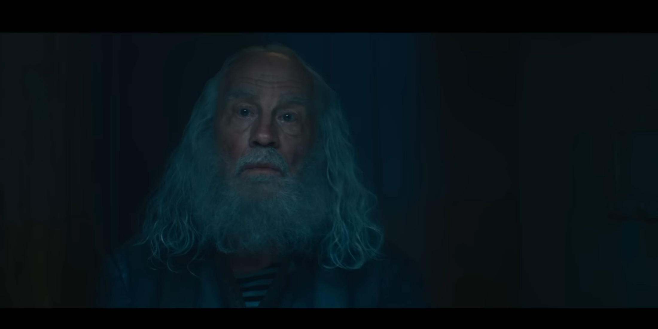 An elder character in a dimly lit room, possibly hinting at a connection to Doctor Doom's origin