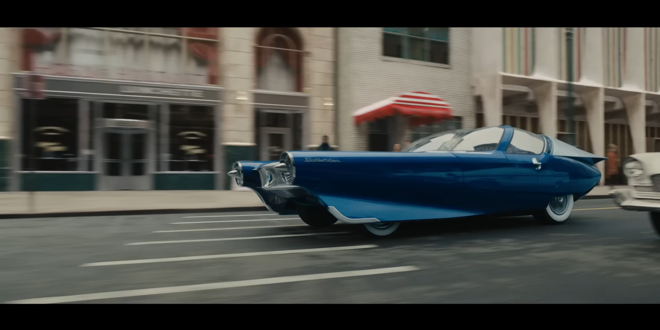 Futuristic blue car inspired by 50s Cadillac design, possibly referencing early Fantastic Four comics