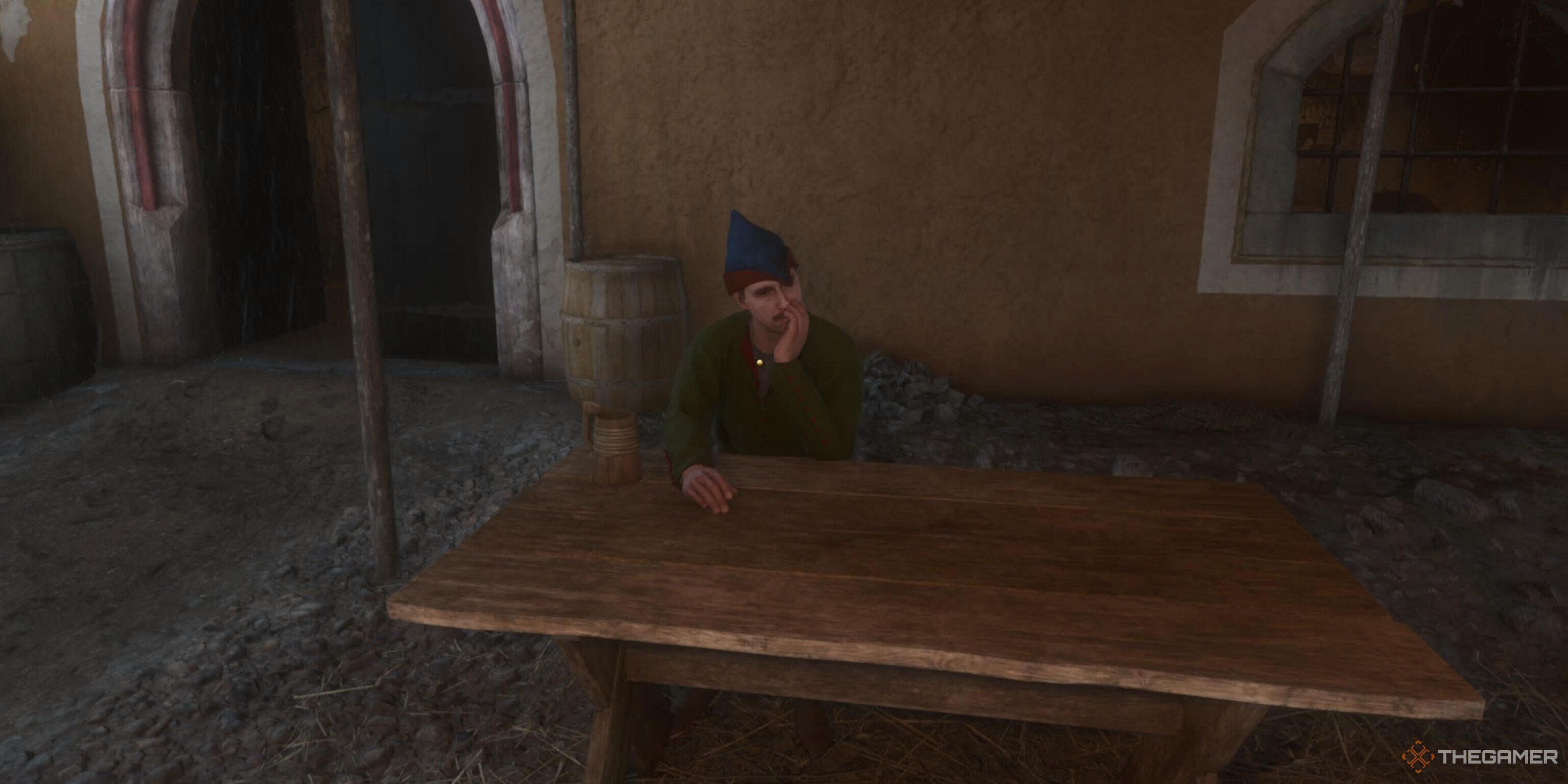 A man sat at a bench drinking in Kingdom Come: Deliverance 2.