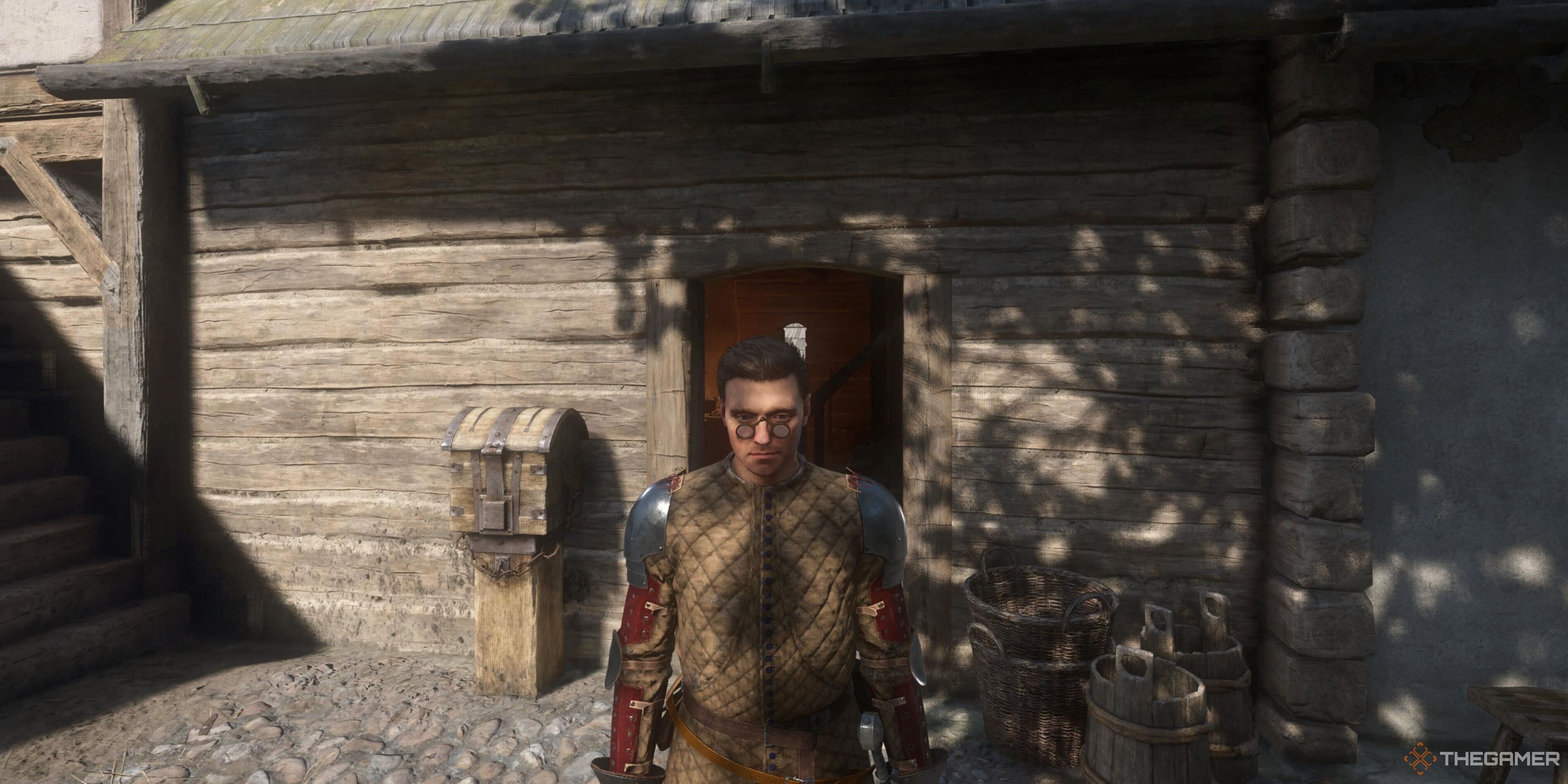 Henry in front of a hut in Kingdom Come: Deliverance 2.