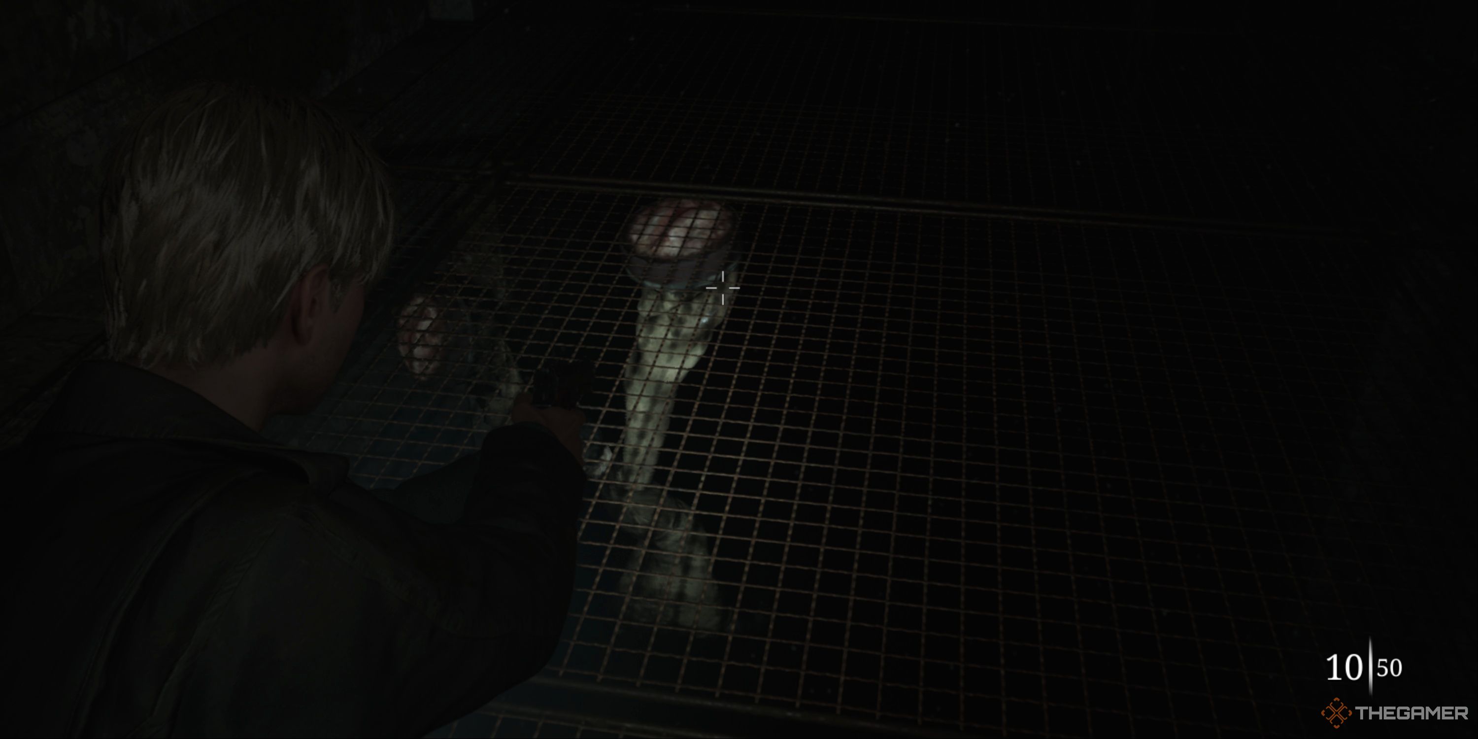 Silent Hill 2 - James aiming his gun at a Mandarin monster that's suctioning to the caged floor below him.