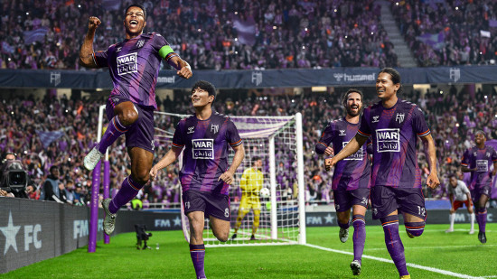 Best FM24 mods: a group of players celebrating in purple kits