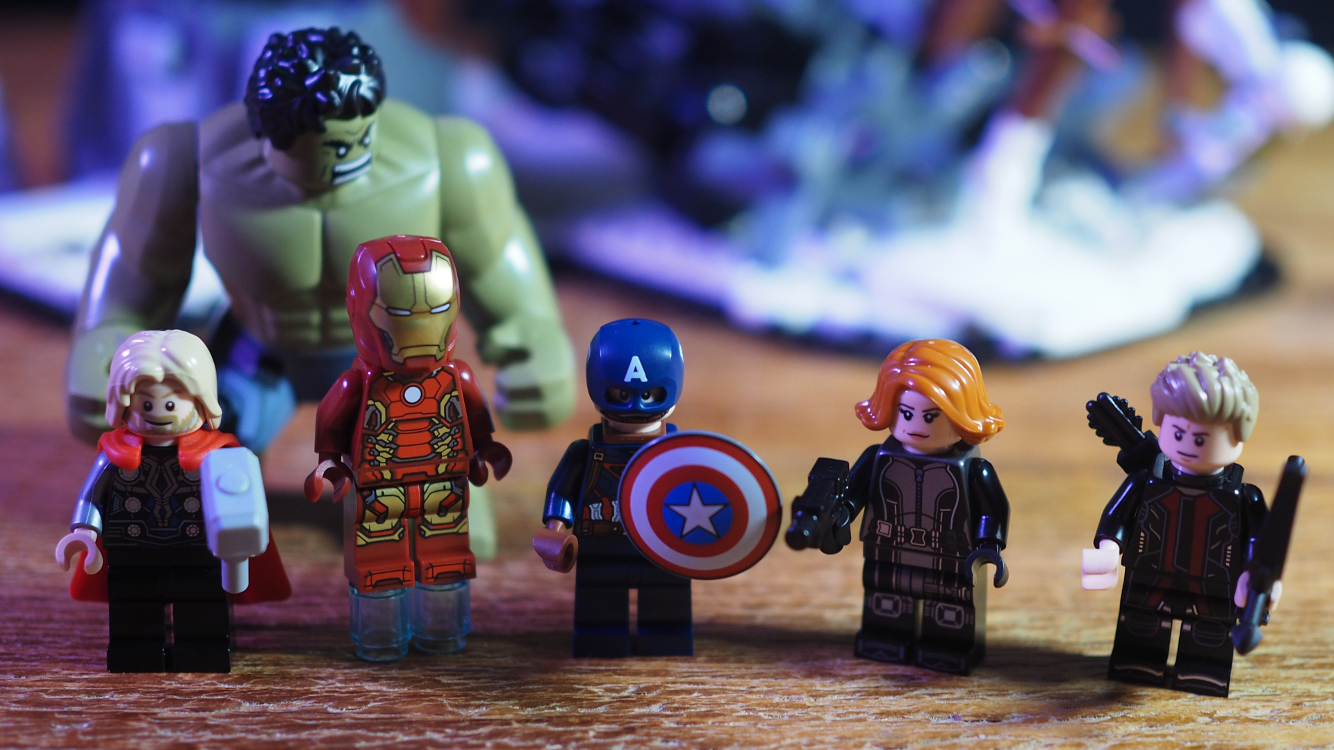 Lego Avengers minifigures lined up on a wooden surface