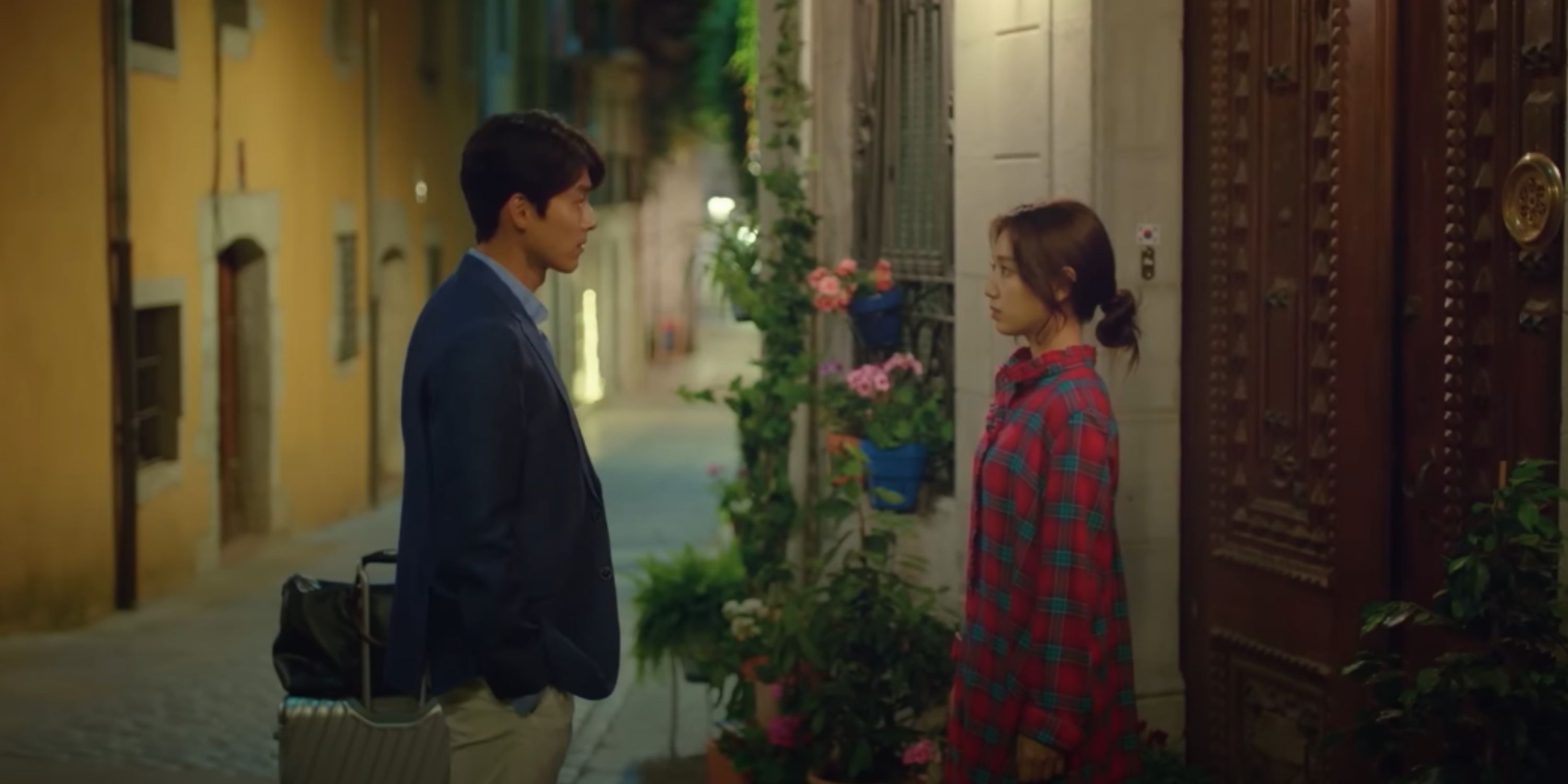 Jin-woo and Hee-joo stand before one another in front of the hostel in Memories Of The Alhambra.