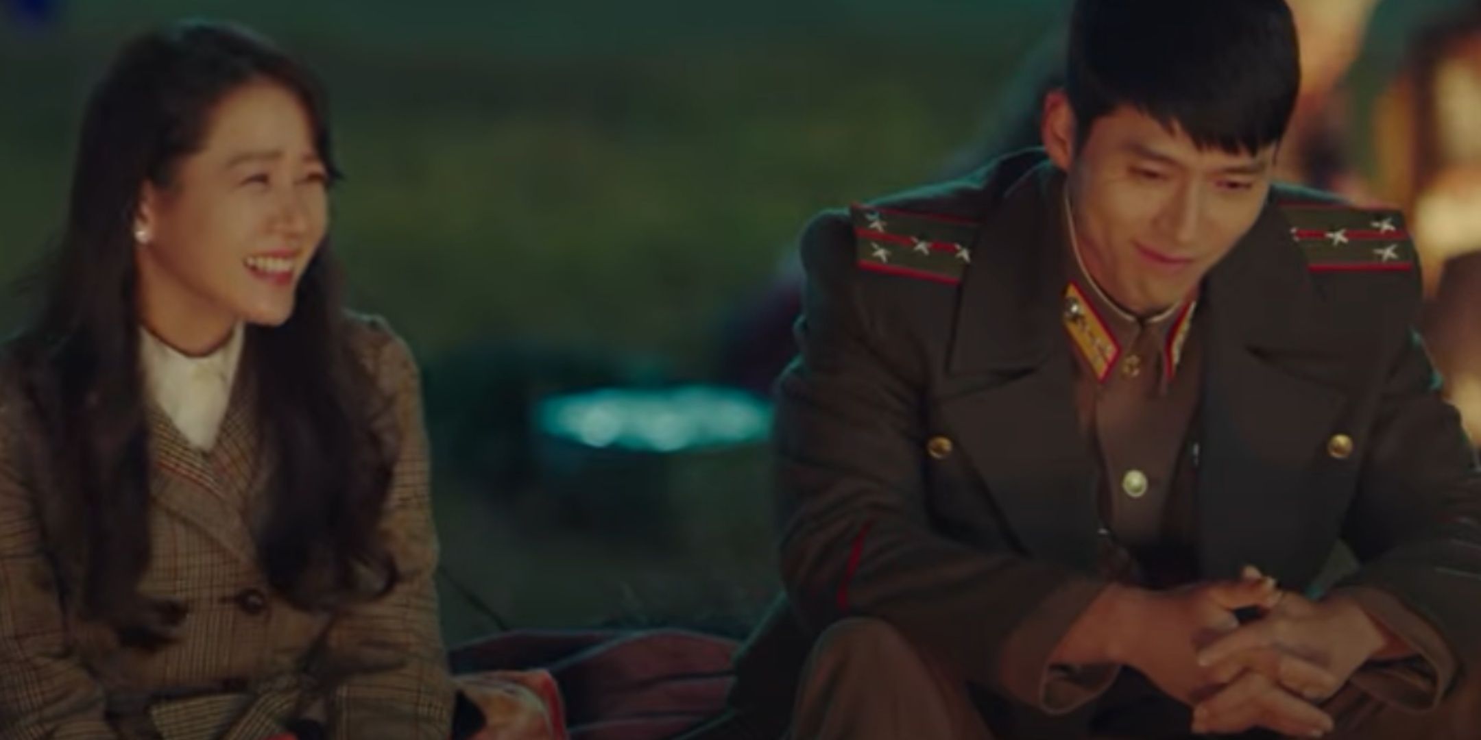 Se-ri and Jeong-hyeok laugh and bond over a campfire in Crash Landing On You.