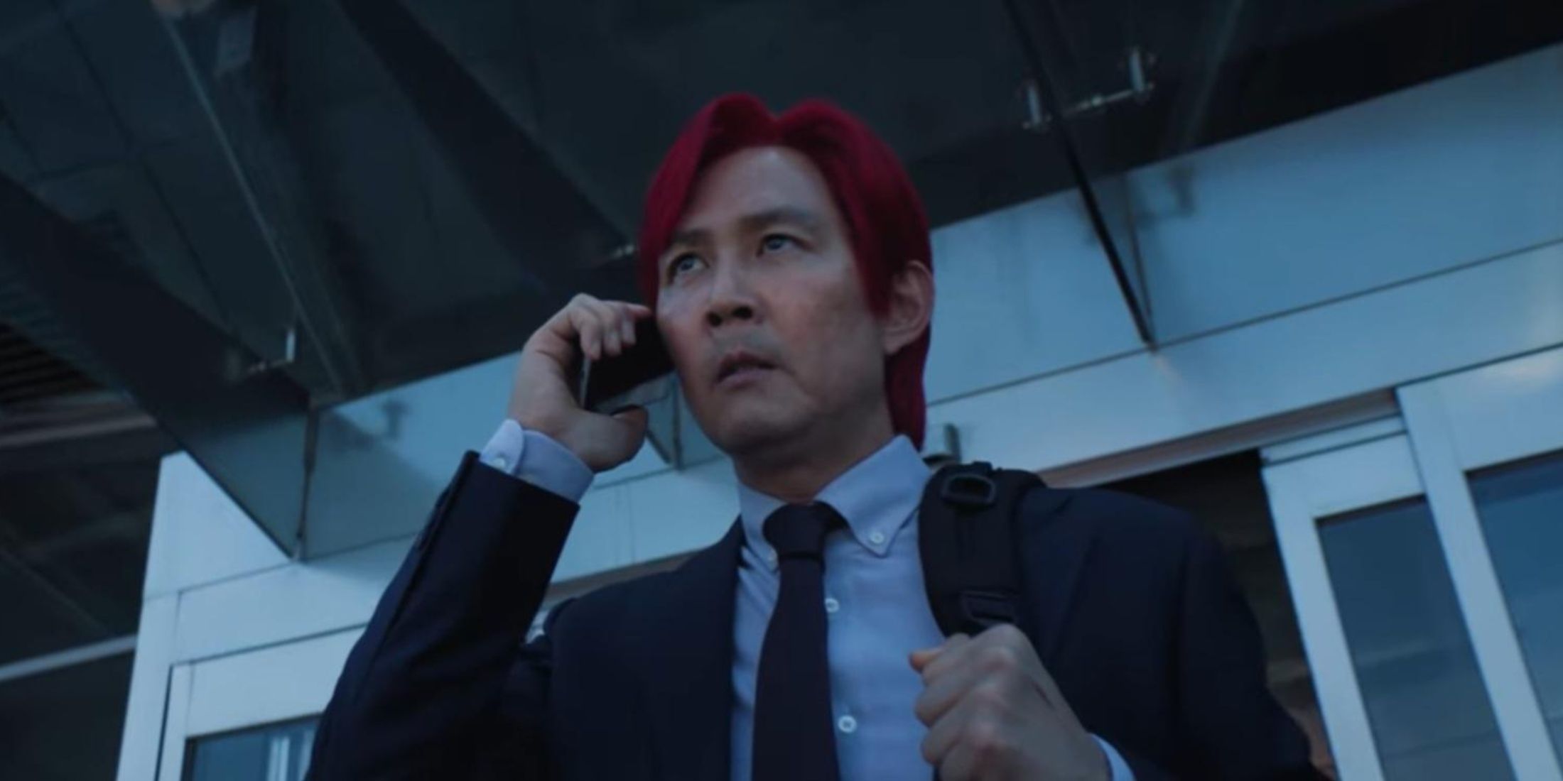 a red hair men speaking on the phone outside the airport