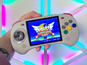 Hand holding Anbernic RG ARC-D handheld with Sonic the Hedgehog 2 gameplay on screen