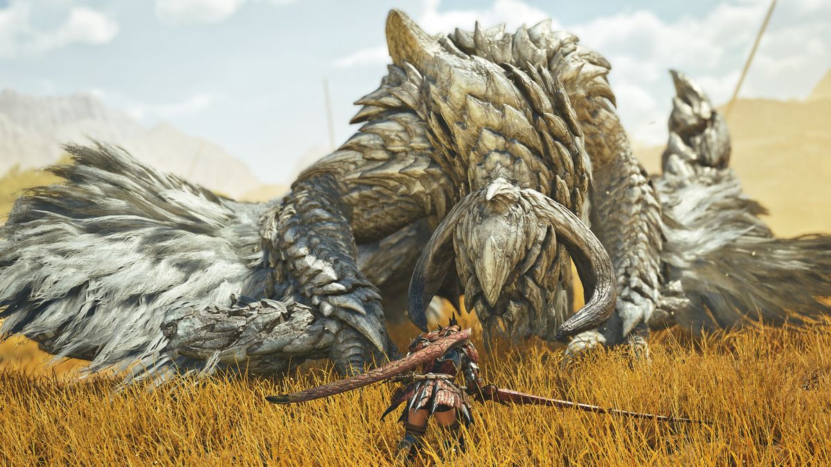 The hunter faces down The White Wraith, an Arkveld, in a grassy plain in Monster Hunter Wilds