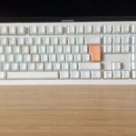 Ducky One X gaming keyboard in white standing upright on a wooden desk