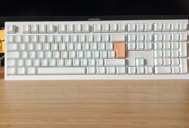 Ducky One X gaming keyboard in white standing upright on a wooden desk