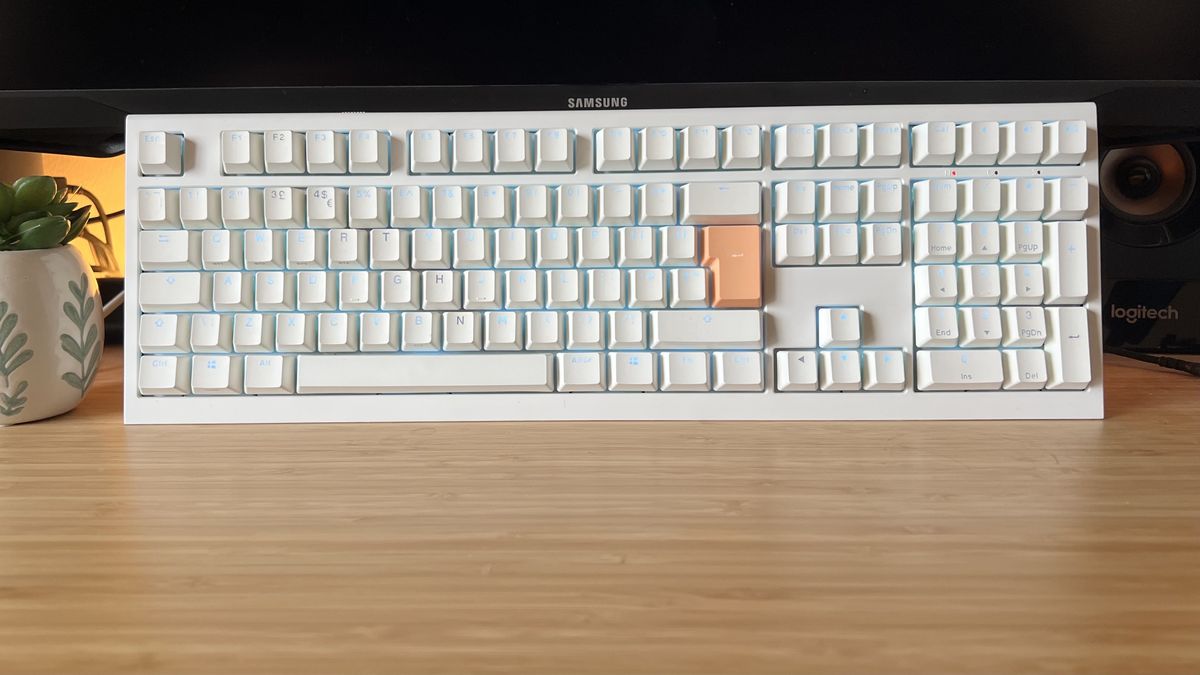 Ducky One X gaming keyboard in white standing upright on a wooden desk