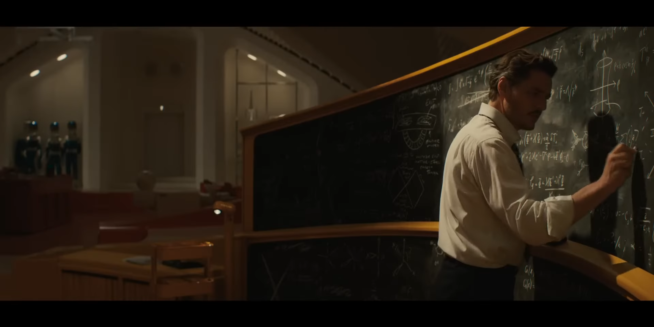 Reed Richards writes equations on a chalkboard, surrounded by hidden Fantastic Four-themed diagrams