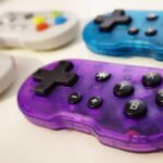 Photo by writer Rosalie Newcombe of a set of four ATOM controllers, with a focus on the Atomic Purple version and the others in the background.