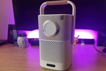 Yaber T2 projector with lens cap on on a wooden desk