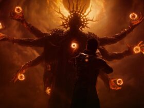 Saros screenshot featuring the main character and am imposing monster in the background with a swirling void in its chest and multiple arms with balls of fire