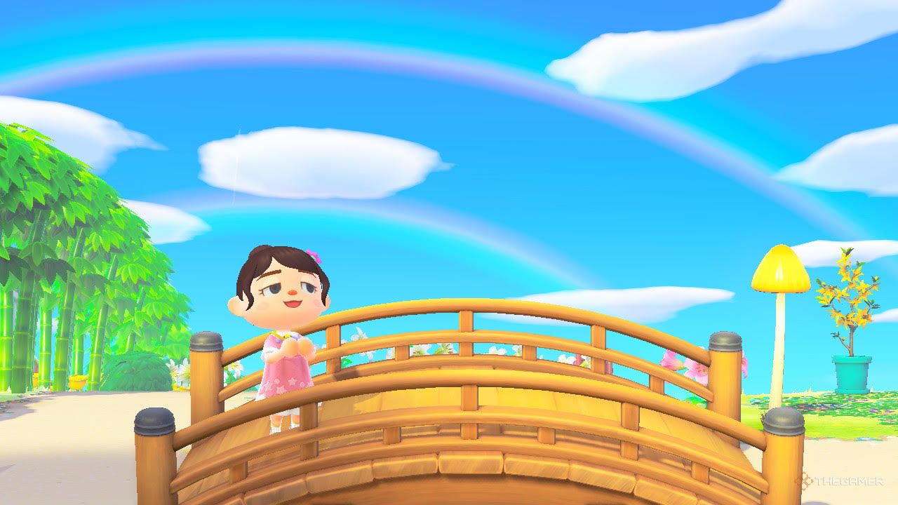 Player standing on a bridge under a double rainbow in Animal Crossing New Horizons.