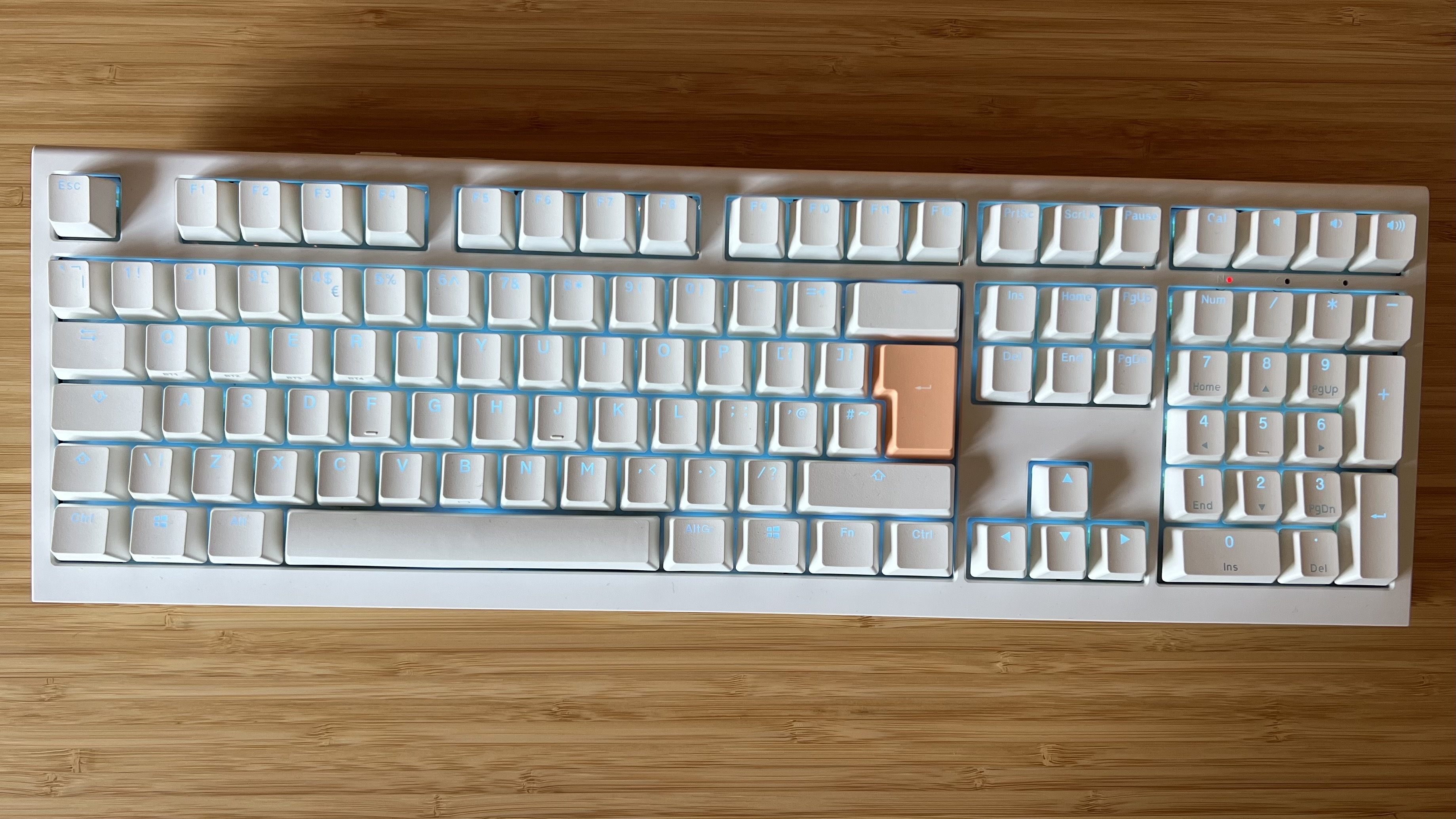 Ducky One X gaming keyboard on a wooden desk