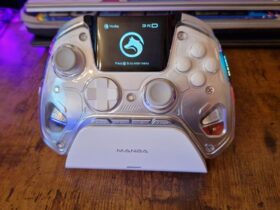 A Manba One review image showing the controller in its charging stand with its display on