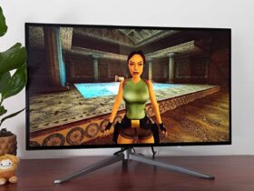 27-inch KTC G27P6 OLED monitor on desk next to plant with Tomb Raider Trilogy gameplay on screen