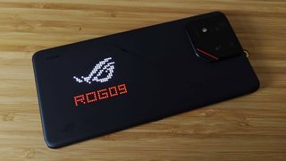 Asus ROG Phone 9 Pro with AniMe lighting at back illuminated with red words reading 