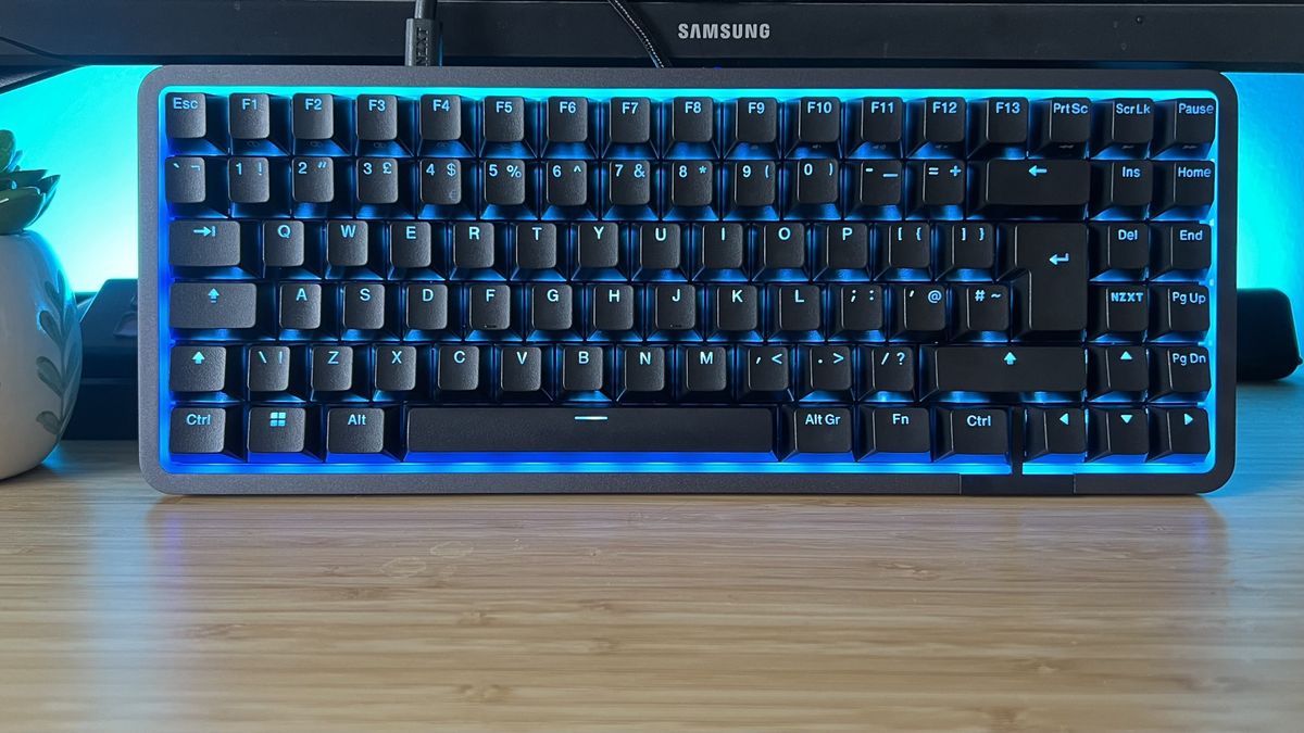 NZXT Function Elite Mini TKL gaming keyboard with blue RGB lighting set against a blue gaming setup