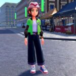 the female protagonist in pokemon legends z-a standing in a city street. she's wearing wide-legged pants, a series first