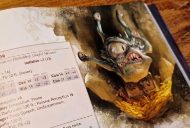 The Monster Manual Spectator artwork and stat block, lying against a wooden surface