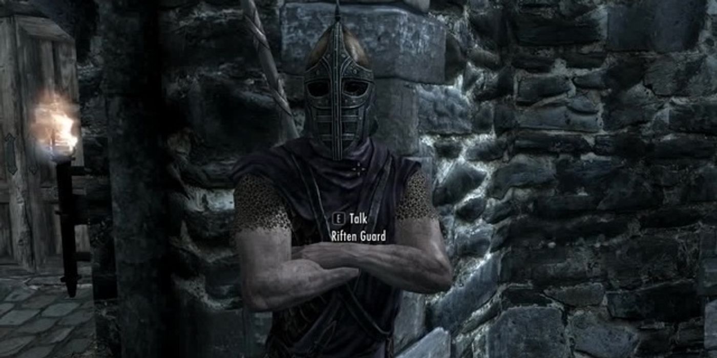 A guard with his arms crossed at night in Skyrim. 