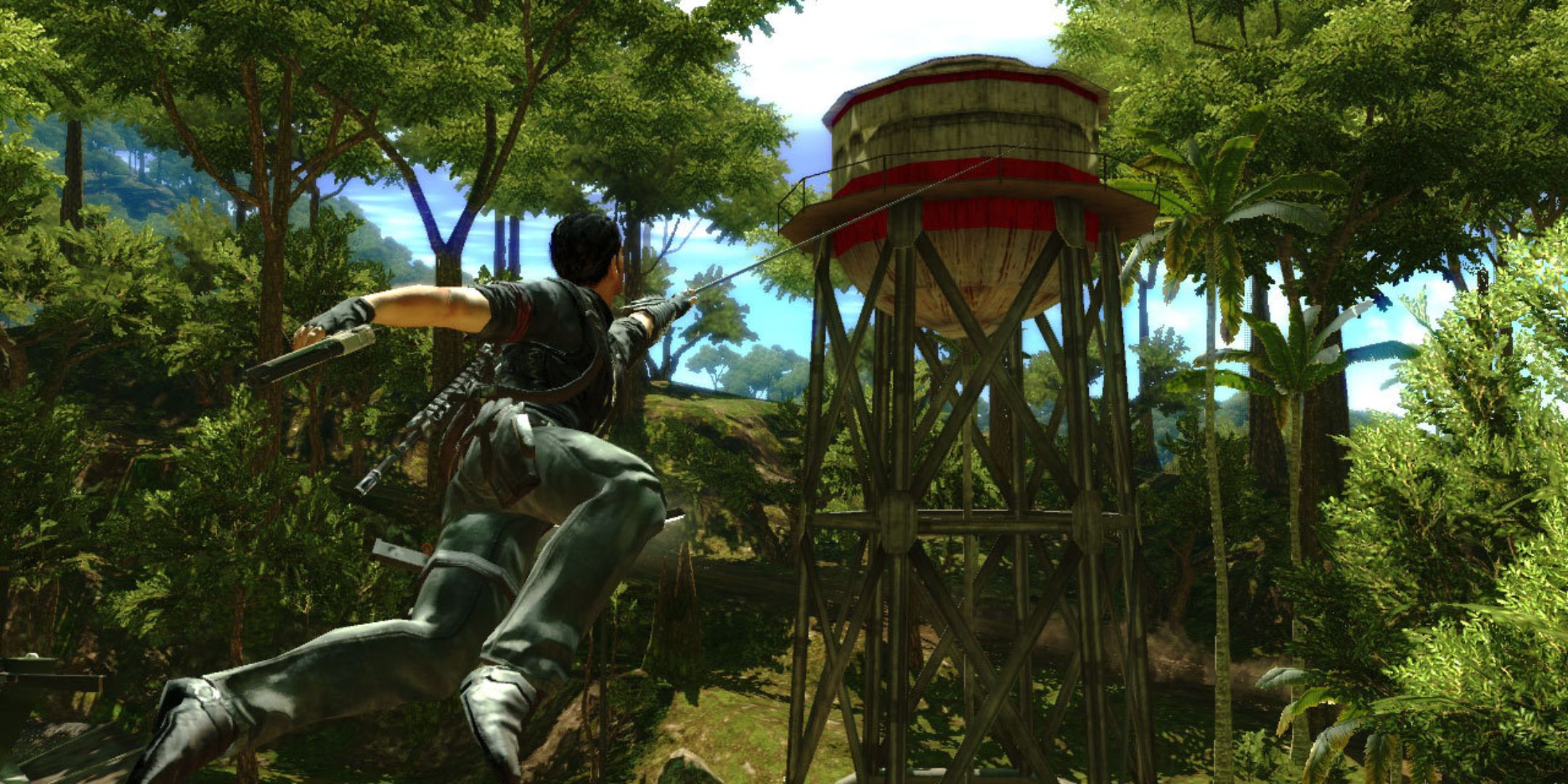 Just Cause 2 screenshot of Rico Rodriguez grappling onto water tower.