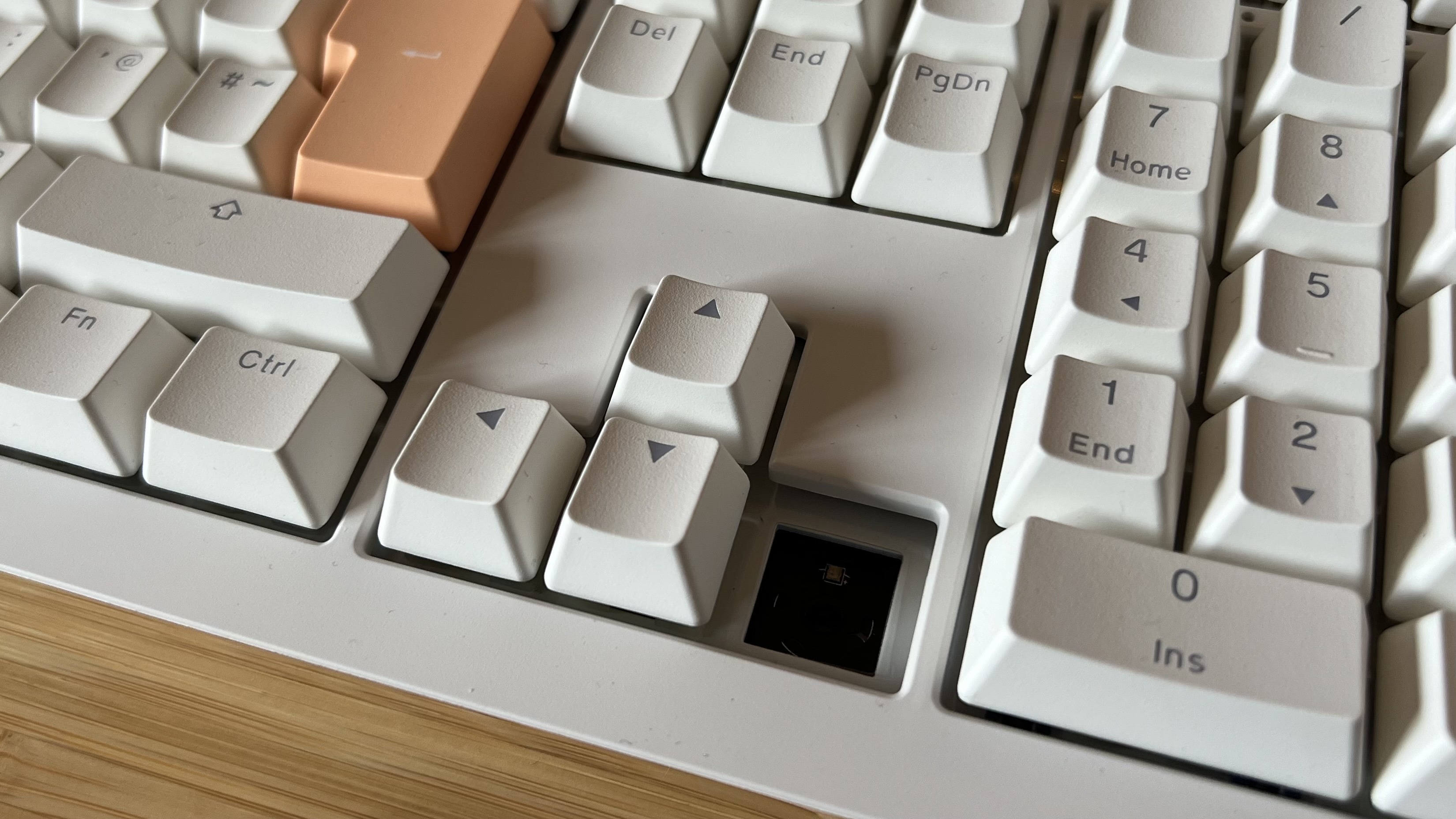 Ducky One X keyboard with switch and keycap removed in the arrow buttons