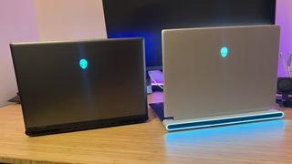 Alienware M16 R2 and Alienware X16 R2 rear lids with RGB switch on on a wooden gaming desk