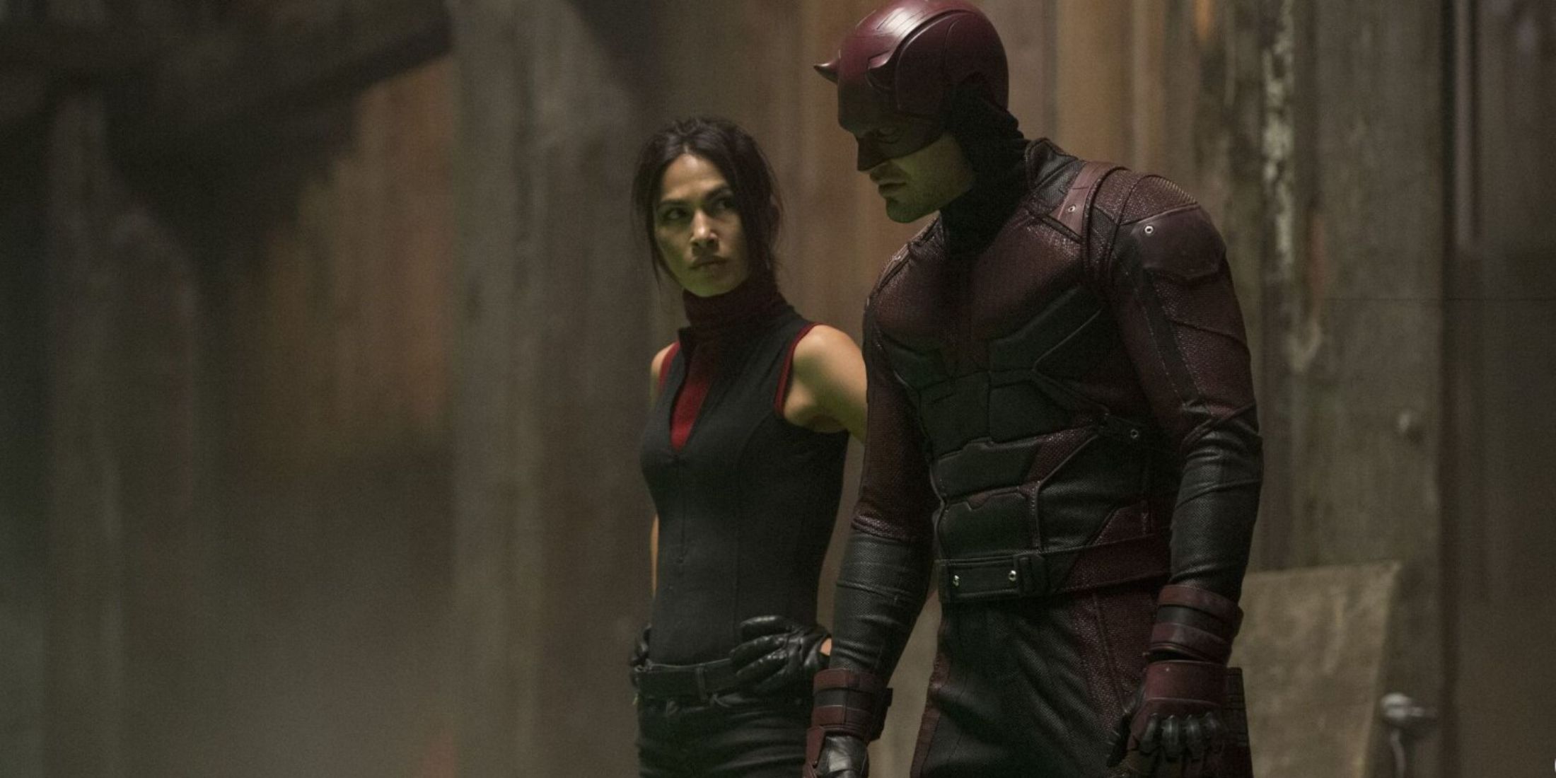 In a dark alley, Daredevil and Elektra exchange glances, sensing danger nearby.jpg