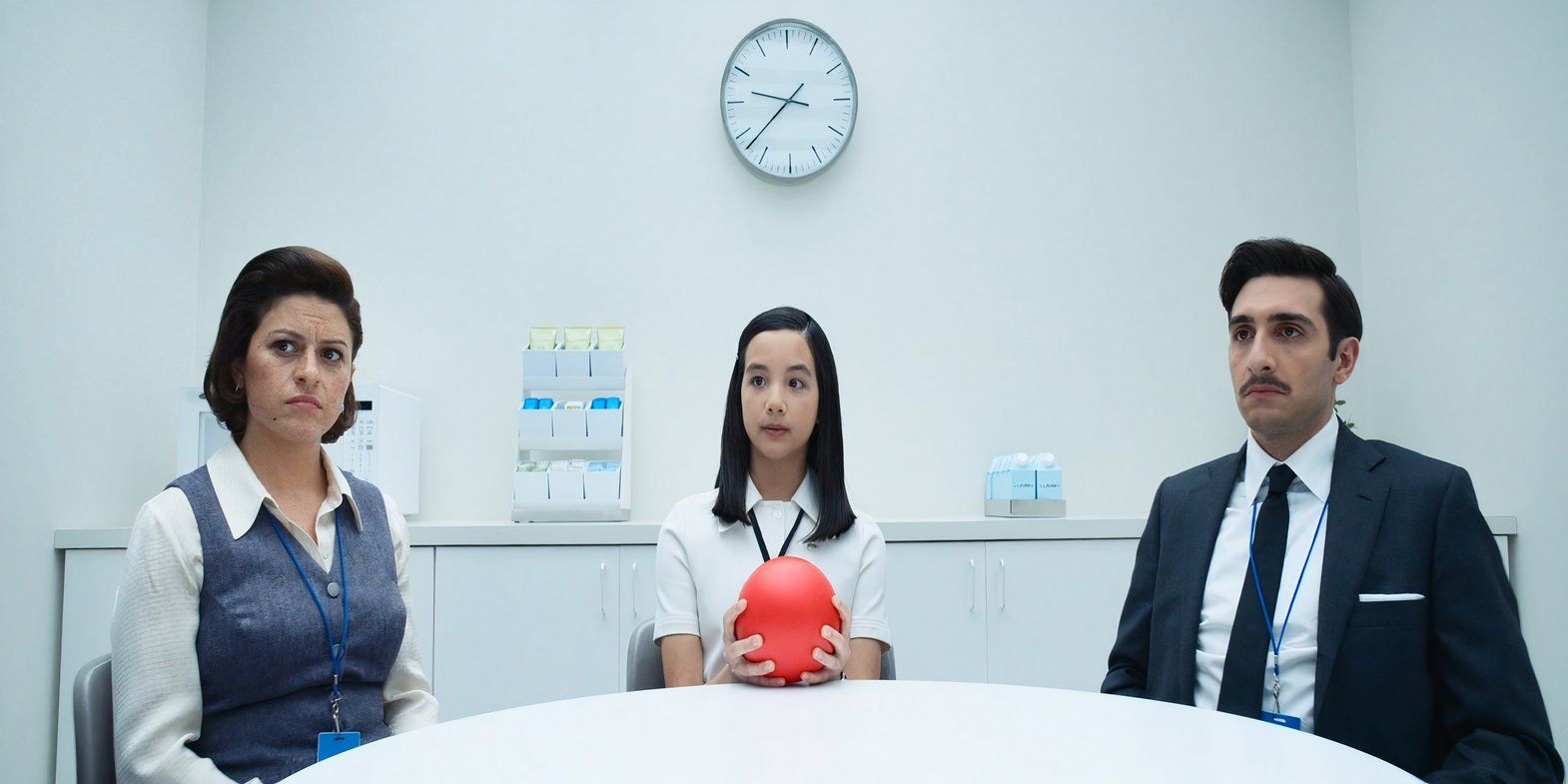 Miss Huang holding a ball beside Mark's new coworkers in Severance