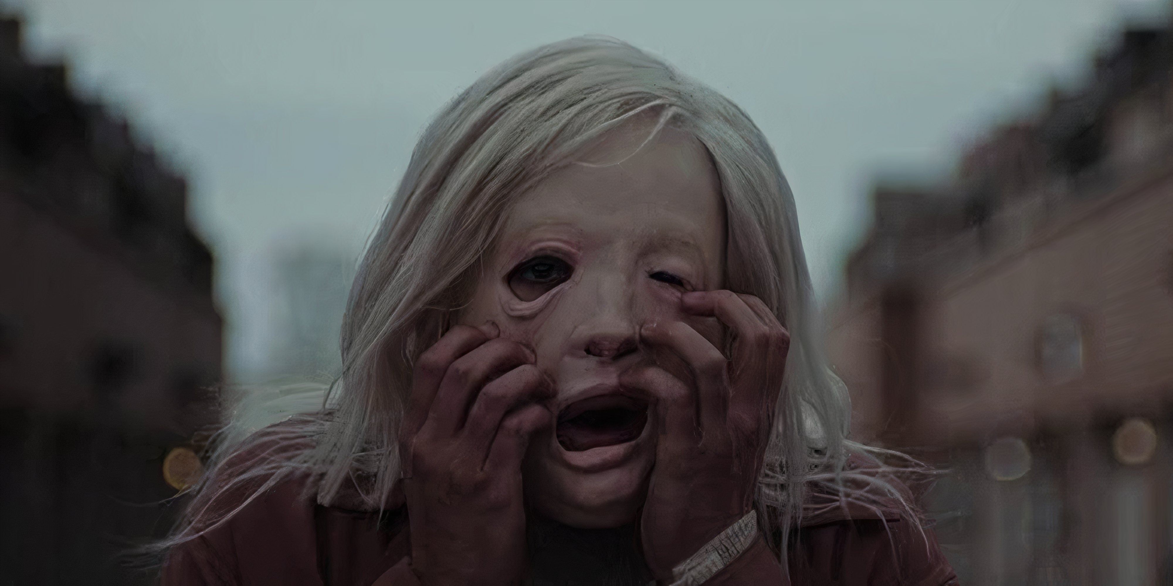 8 Best Body Horror Movies of the 2020s A Woman claws at her mask-like face