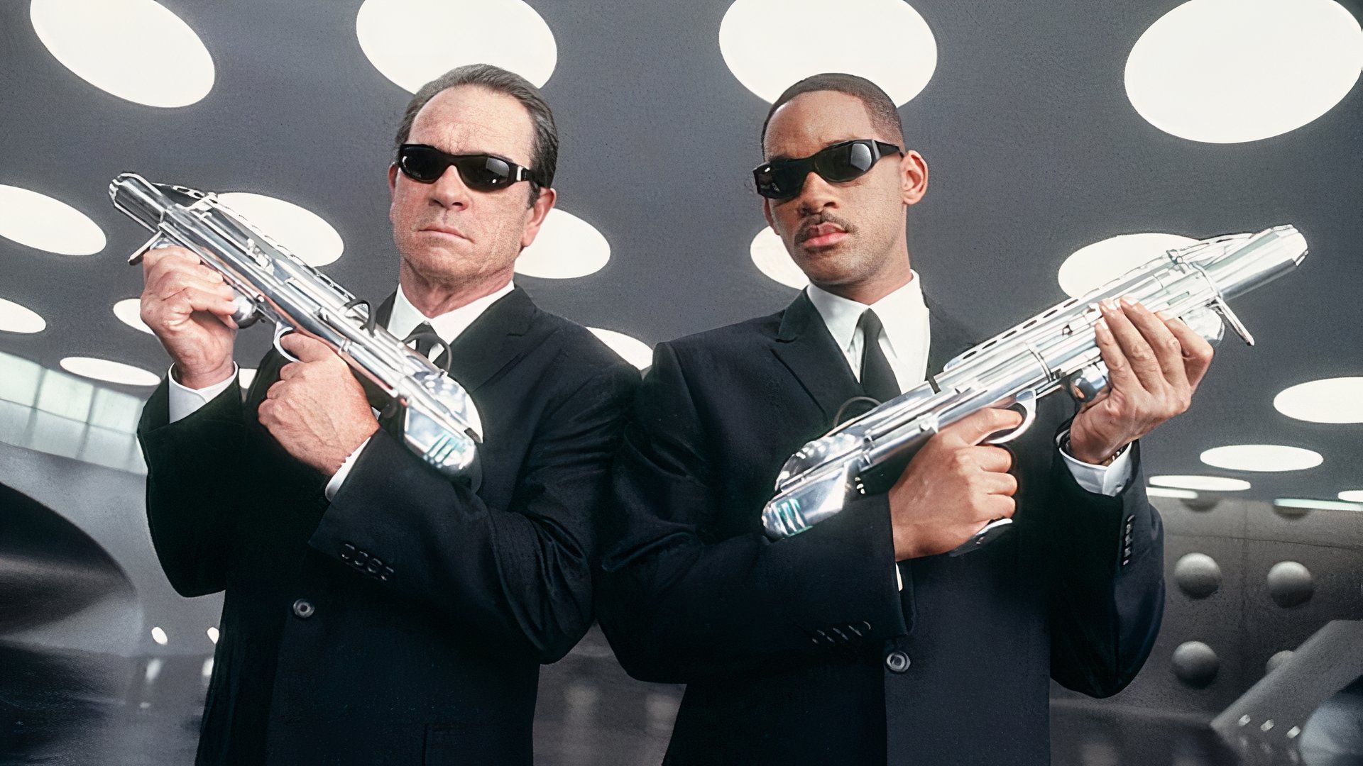 Tommy Lee Jones and Will Smith posing with their weapons in Men in Black II's trailer.