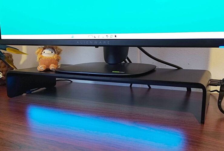 Razer Monitor Stand Chroma on desk with blue lighting reflecting off surface and Alienware gaming monitor on top.