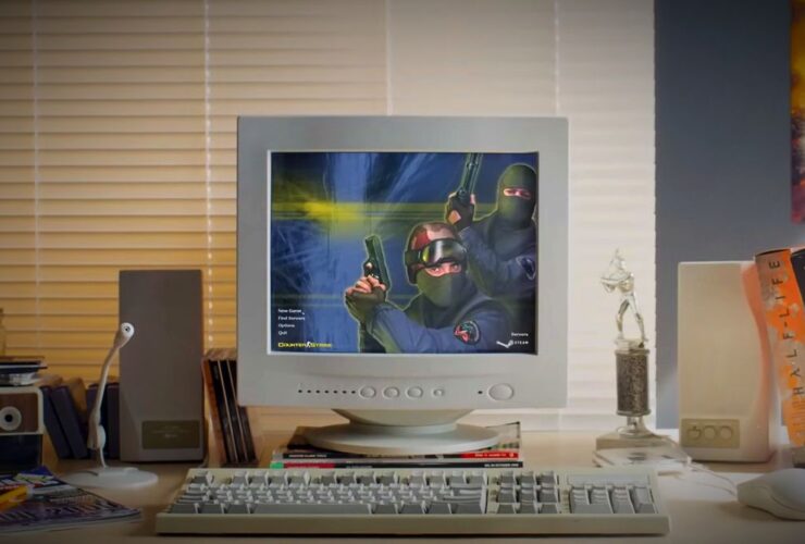 Counter-Strike 2 release trailer screenshot showing an old-style white desktop PC running the Counter-Strike menu atop a wooden desk