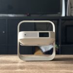 XGIMI Elfin Flip projector on a coffee table with a TV in the background