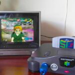 Nintendo 64 console with SummerCart64 inserted on desk with Panasonic CRT TV and Zelda: Nightmare ROM hack on screen.