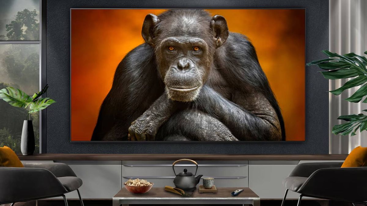 LG OLED G5 mounted on wall with chimpanzee on screen and coffee table with tea pot and popcorn on top.