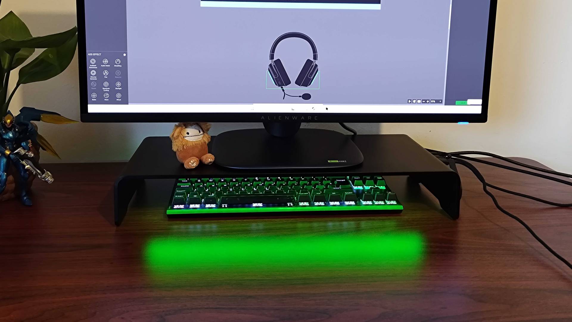Razer Monitor Stand Chroma with green RGB lighting reflecting off desk and Alienware monitor on top.