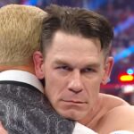 John Cena stares evilly while embracing Cody Rhodes