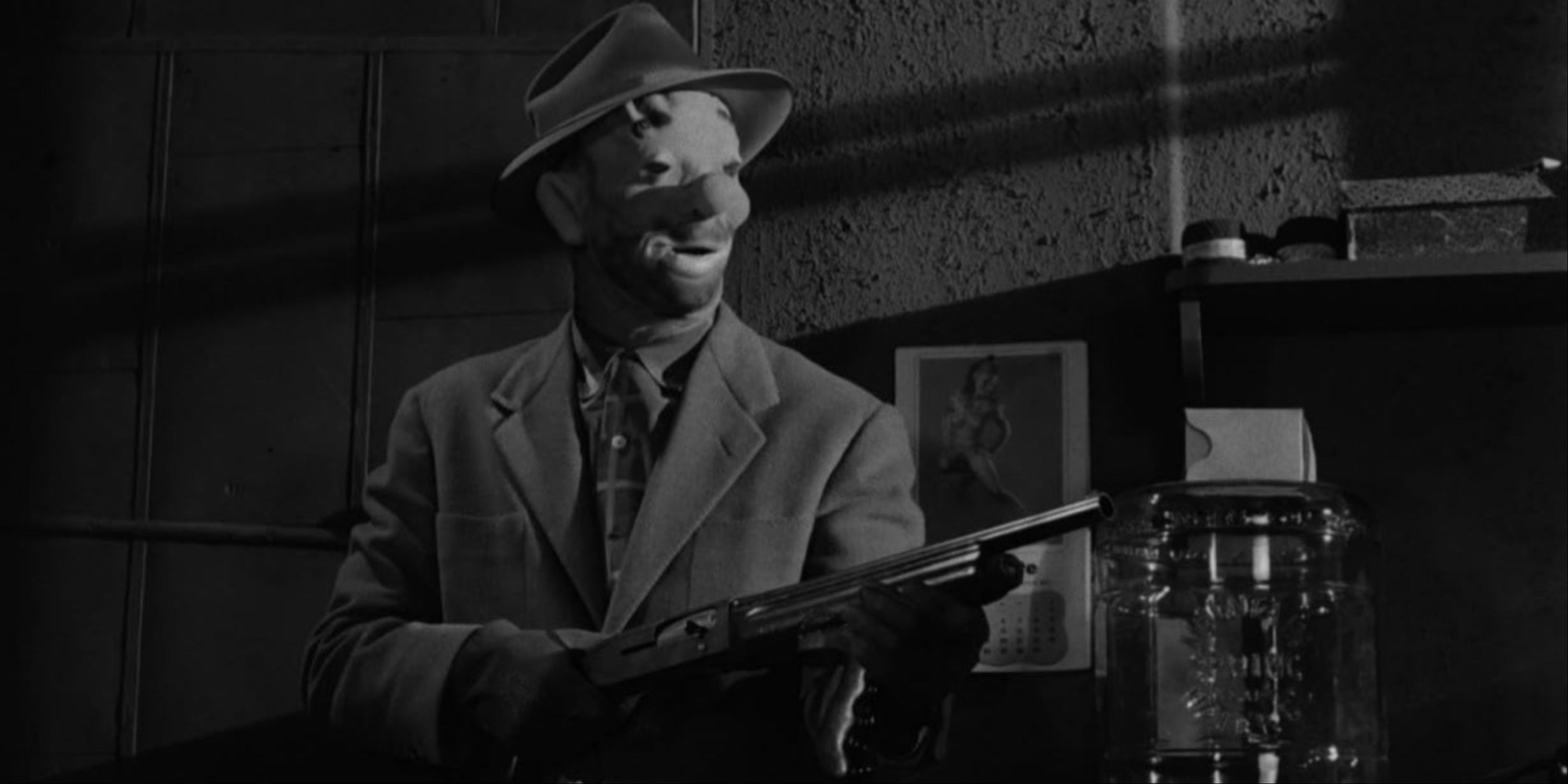 A masked character pointing a gun at others while committing a robbery in The Killing.