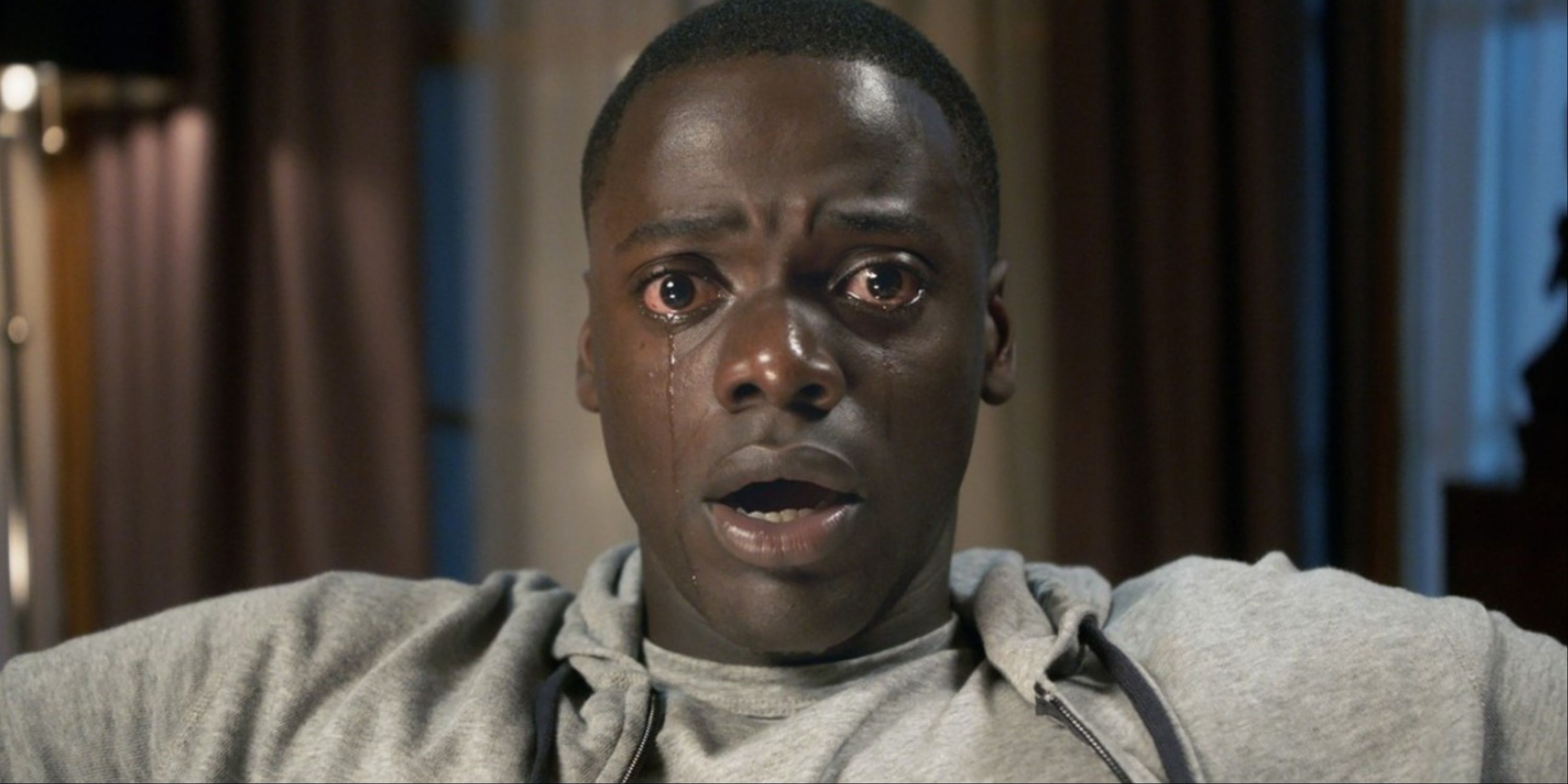 Daniel Kaluuya in the iconic terrifying shot from Get Out where he can't get out of his seat and sheds tears from his eyes.