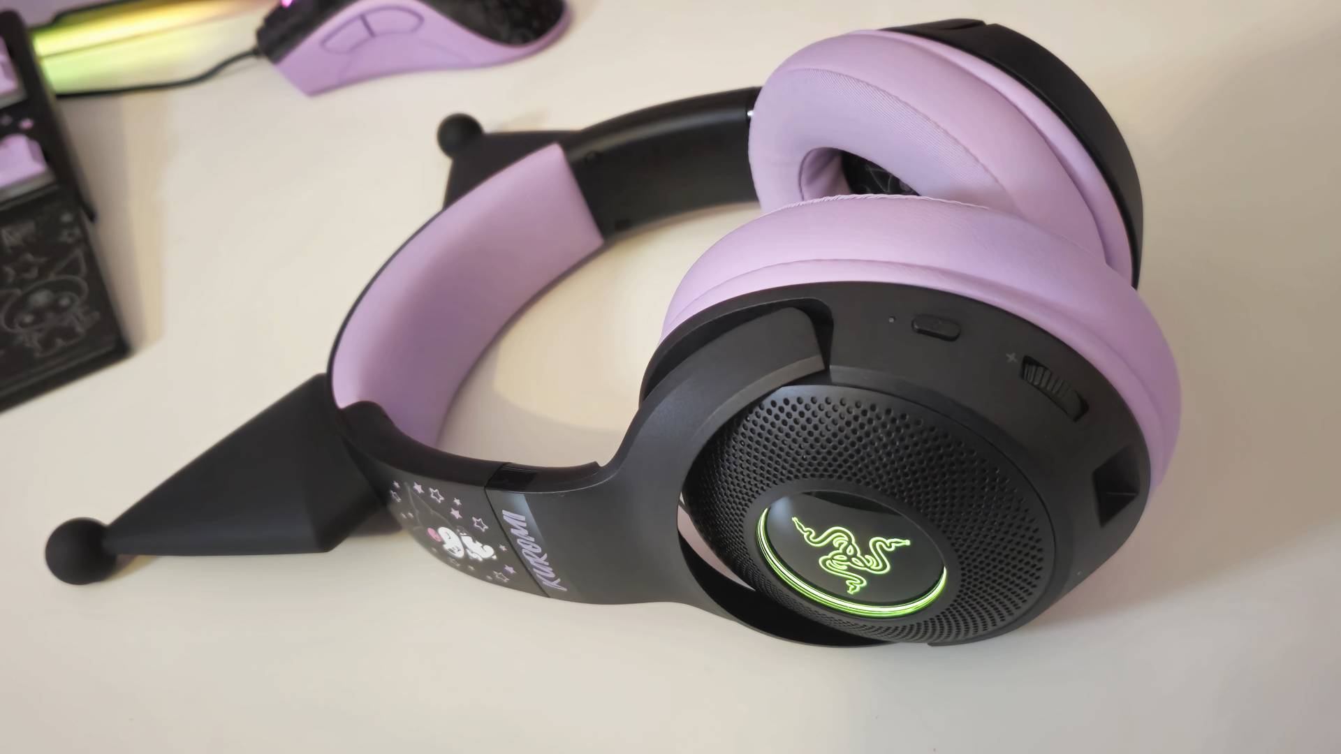 Photos taken by writer Rosalie Newcombe of the Razer Kraken Kitty V2 BT Kuromi Edition gaming headset, on a white desk. 