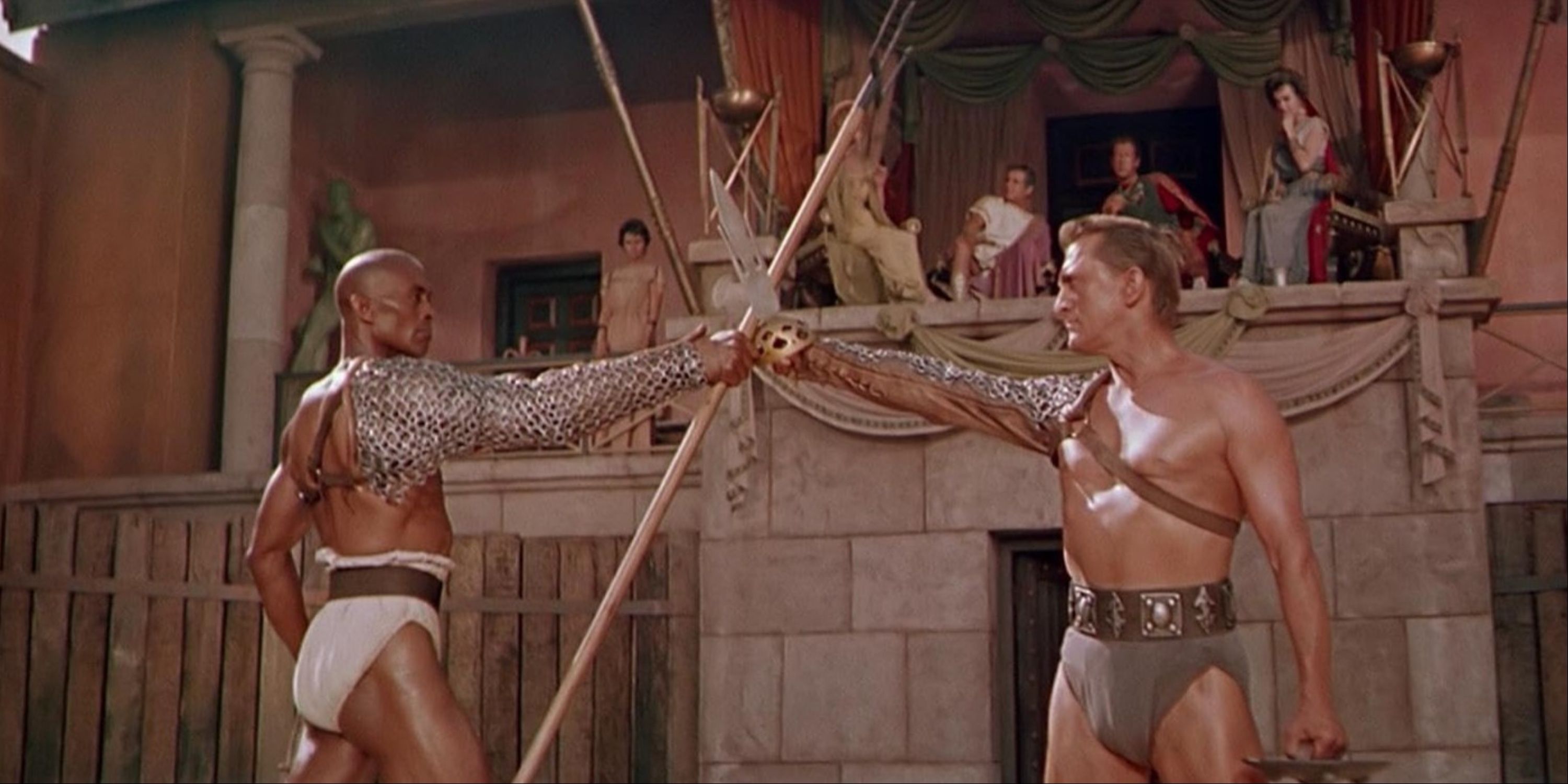 Kirk Douglas' Spartacus locking weapons with Woody Strode's Draba in the gladiator arena before an audience in Kubrick's Spartacus.